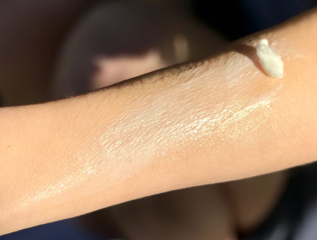 A dab of lavender body butter melting as it is spread across an arm.